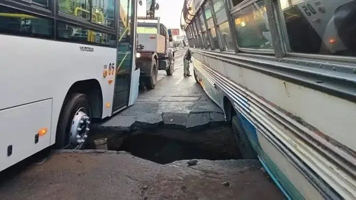 Dos buses atrapados en enorme socavón en Managua